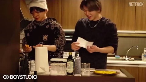 Japanese gay couple cooking together in kitchen