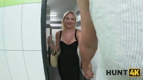 Blonde in black dress smiling at door in adult video thumbnail