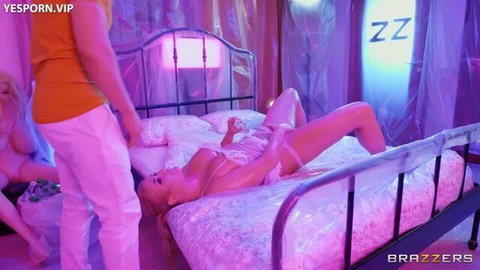 Blonde woman in lingerie on bed with man standing over her in pink neon bedroom