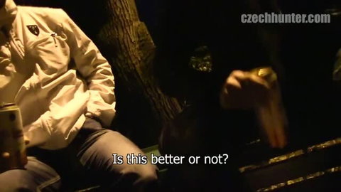 Night outdoor scene with man in white jacket sitting on bench