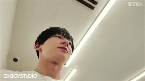 Young Japanese man looking up in bright room, soft lighting, short black hair