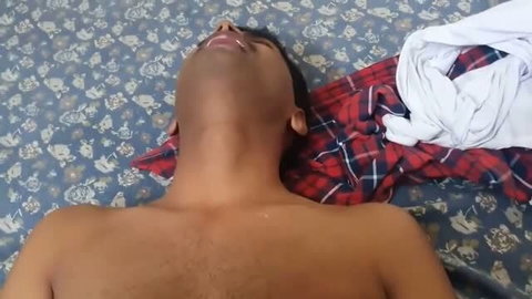 Shirtless Indian man lying back on bed during homemade porn scene