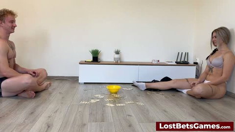Couple playing strip cards game on floor, woman in lingerie