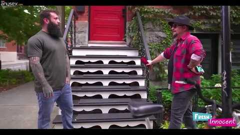 Two bearded men in casual clothes standing outside house with red door