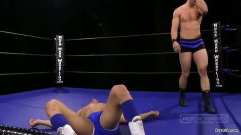 Two muscular wrestlers in blue singlets on wrestling mat