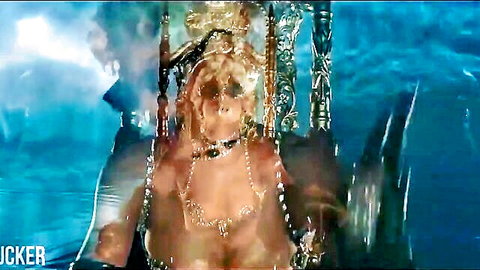 Blonde woman in ornate gold jewelry posing nude underwater