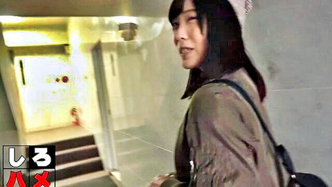 Brunette Japanese student girl smiling teasingly in school corridor