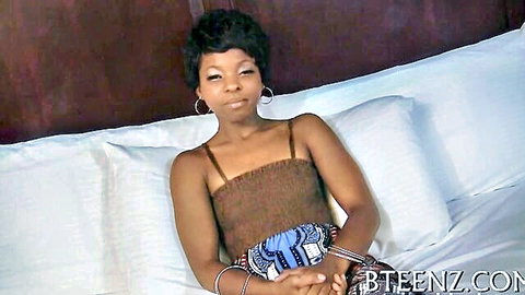 Sexy ebony teen with short hair smirking seductively in tight tube top on bed