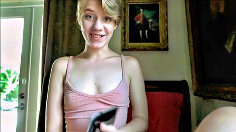 Dakota Burns smiling in tight pink tank top, teasing cleavage