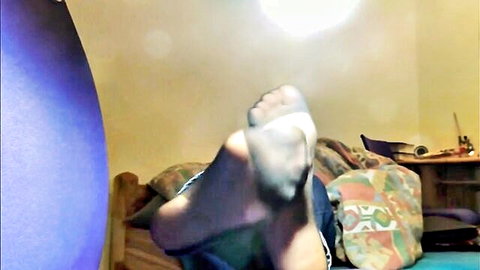 Close-up of nylon-covered feet soles in seductive pose