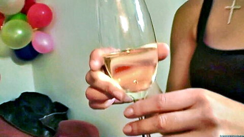 Carla Cox toasting with rosé wine, cross necklace on black top, party balloons
