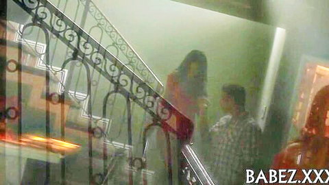 Busty minx in red dress talks to man on stairs, teasing preview for hard nailing