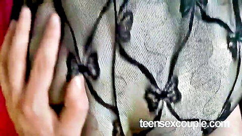 Seductive teen in sheer black lace bodystocking, hand teasing breast