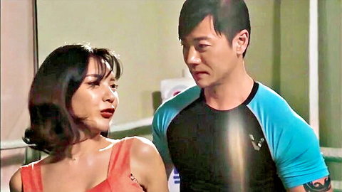 Asian couple in workout gear, intimate gym moment with woman in red top