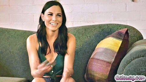 Brunette Katie in low-cut green top showing luscious cleavage smiling