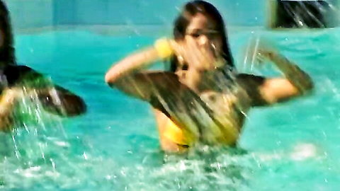 Wet Brazilian babes in yellow bikinis splashing in pool orgy scene
