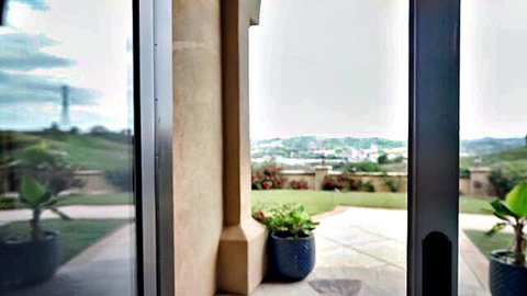 Chloe Surreal outdoor patio view with lush plants and hills