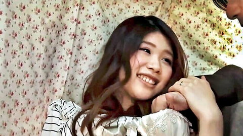 Smiling Japanese woman in striped blouse, intimate moment with man's hand on arm