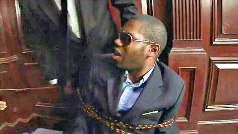 Ebony man in suit and sunglasses chained with mouth wide open gasping