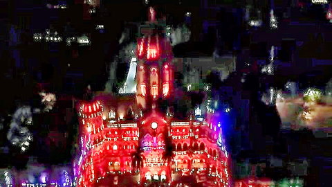 Vibrant red and blue lit CST Mumbai train station at night glowing passionately