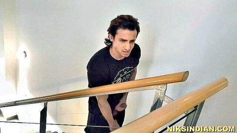 Indian man in black t-shirt on staircase, suggestive pose