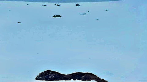 Elena Koshka nude posing on snowy rock in outdoor winter scene