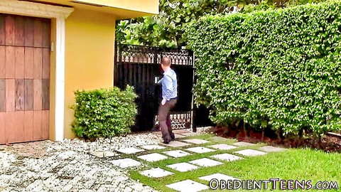 Balding man in blue shirt walks through black gate into yellow house yard at ObedientTeens.com