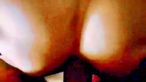 Tanned woman's spread ass cheeks exposing pink anus and wet pussy with red toy at asshole