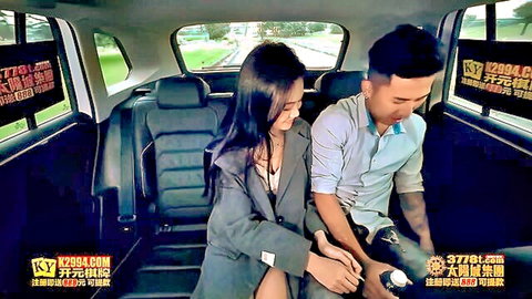 Asian woman in suit teases tattooed man in car backseat foreplay