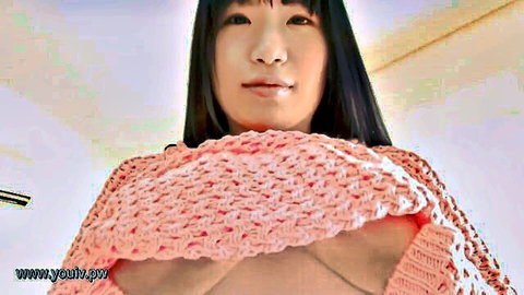 Smiling Asian woman exposes perky breasts in pink knitted sweater, POV close-up