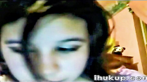 Blurry closeup of cute amateur Asian girl's wide-eyed face on webcam solo tease