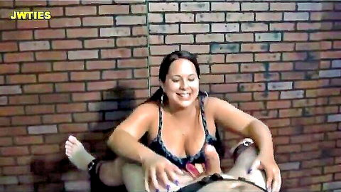 Curvy brunette in lingerie tickles man's cock with red toy, smiling seductively