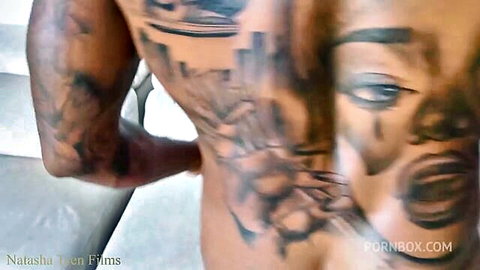 Tattooed muscular black man's bare ass exposed from behind in blurry interracial porn closeup