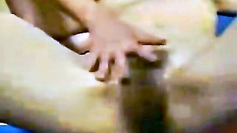 Close-up of hand stroking erect penis between spread thighs