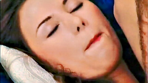 Brunette woman eyes closed lips parted resting on pillow intimate closeup