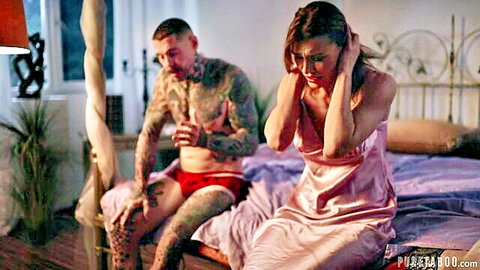 Kitana Lure in pink lingerie distressed on bed with tattooed partner