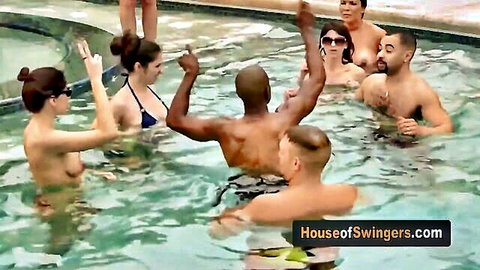 Hot swinger MILF topless in pool, touching muscular guys in group fun