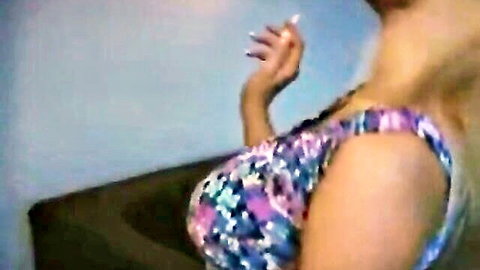 Brandy smoking seductively in colorful bikini top, large breasts